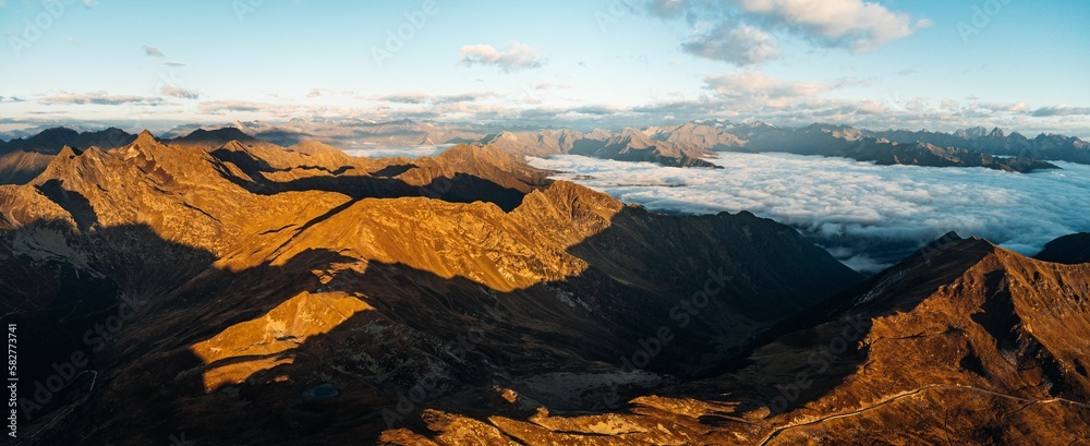 Panoramic view of the steep mountains of the Italian Alps with fluffy clouds in the background