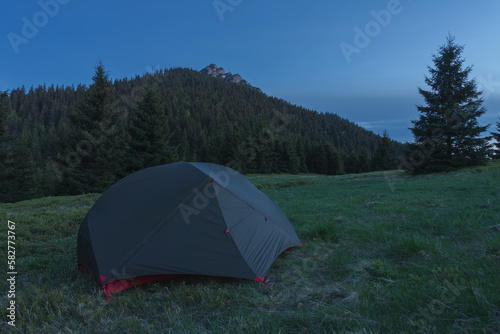 Tent on mountain col in grass in the evening. On background Velky Rozsutec. Mala Fatra mountains, Slovakia.