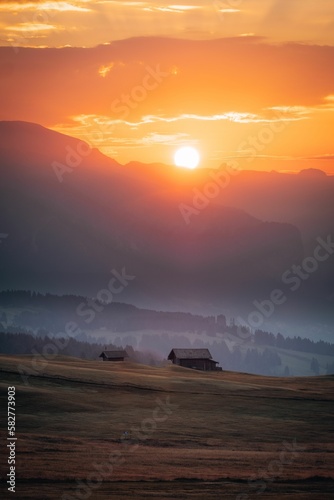 Fototapeta Naklejka Na Ścianę i Meble -  Wooden huts surrounded by the beautiful Dolomites mountains during the sunset
