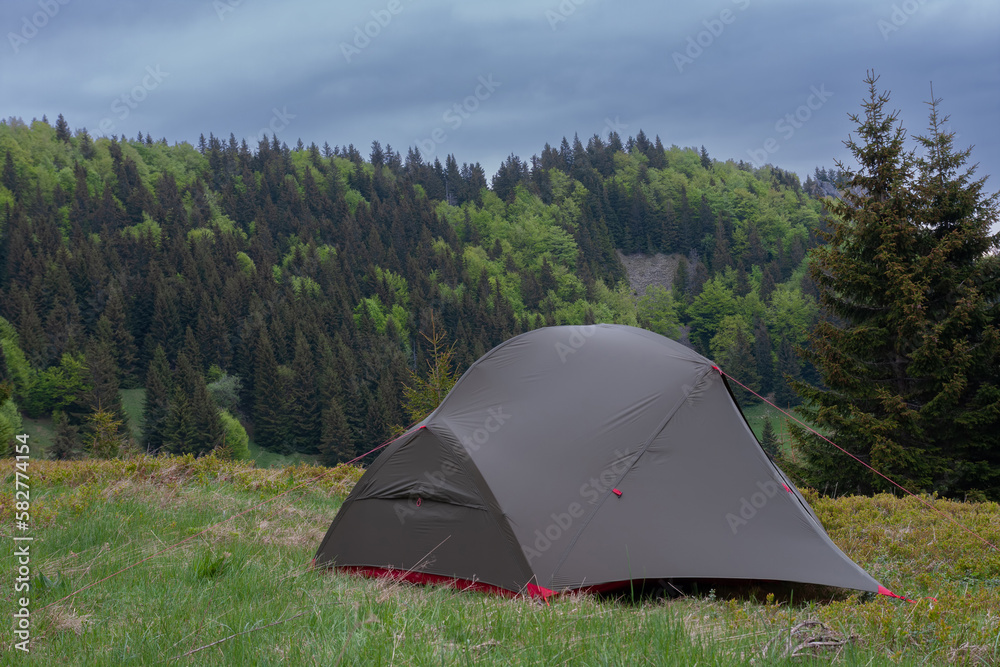 Tent on mountain col in grass in the morning. On background  Mala Fatra mountains, Slovakia.