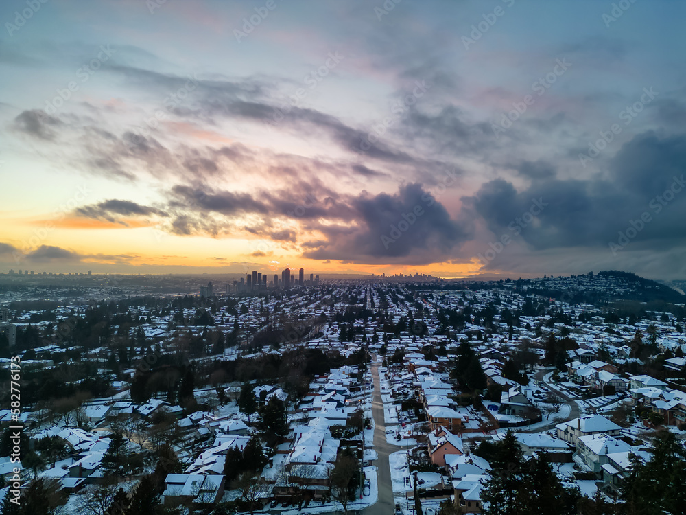 Modern City Suburban Neighborhood covered in snow. Burnaby, Vancouver, BC, Canada. Aerial Winter Sunset