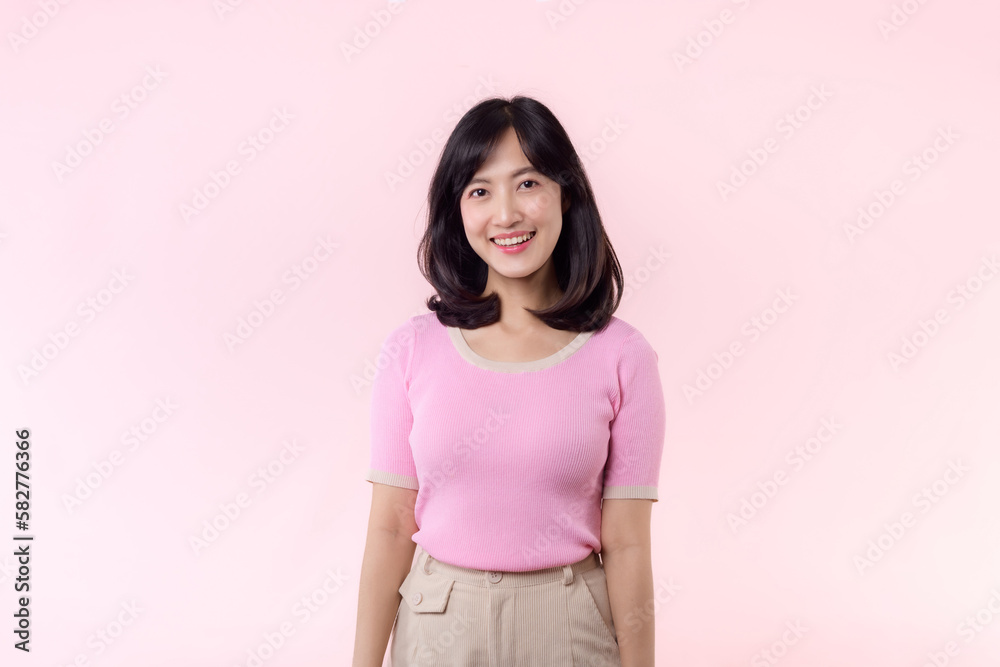Fototapeta premium Portrait beautiful young asian woman model happy smile in pink sweater casual style fashion isolated on pink studio background. Attractive female person cheerful cute face portrait, Woman day concept.