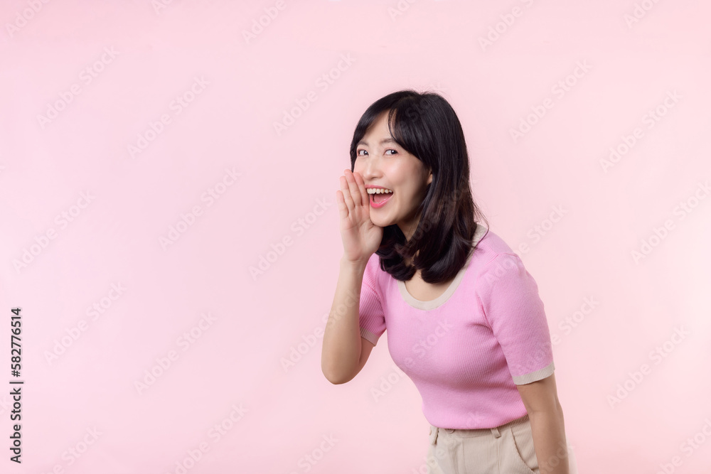 Portrait beautiful young asian woman expression yel scream announce news of communication message or shout loud voice with hand beside mouth gesture isolated on pink pastel background. Portrait beautiful young asian woman expression yel scream announce news of communication message or shout loud voice with hand beside mouth gesture isolated on pink pastel background.
