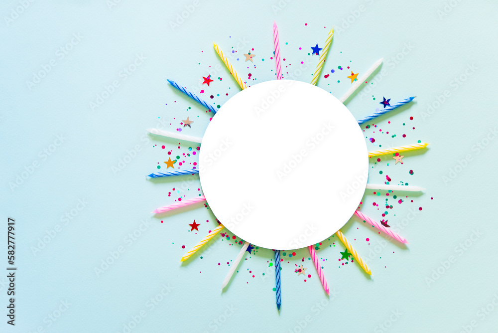Festive frame or blue background with colorful candles, confetti, star. Flat lay, mockup. Happy birthday or party greeting card with copy space.	