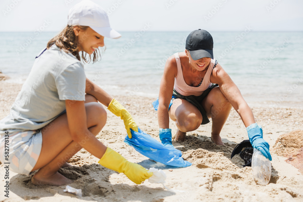 Two Women Volunteers Cleaning Up The Beach Two Women Volunteers Cleaning Up The Beach