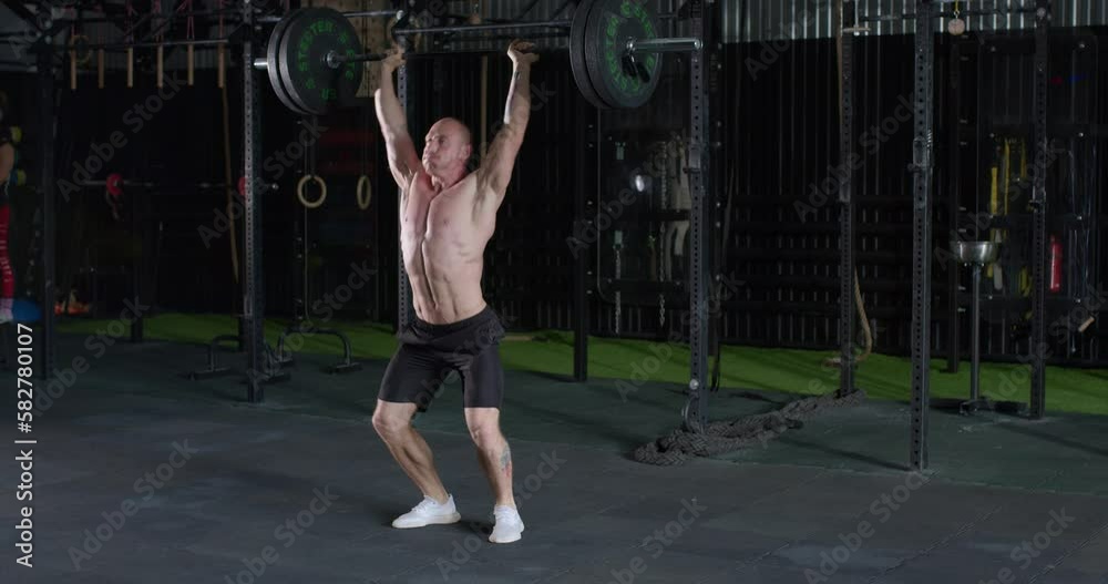 Strong muscular man doing barbell snatch exercise at gym in slow motion. lifestyle free spare time hobby motivation challenge slow motion Strong muscular man doing barbell snatch exercise at gym in slow motion. lifestyle free spare time hobby motivation challenge slow motion