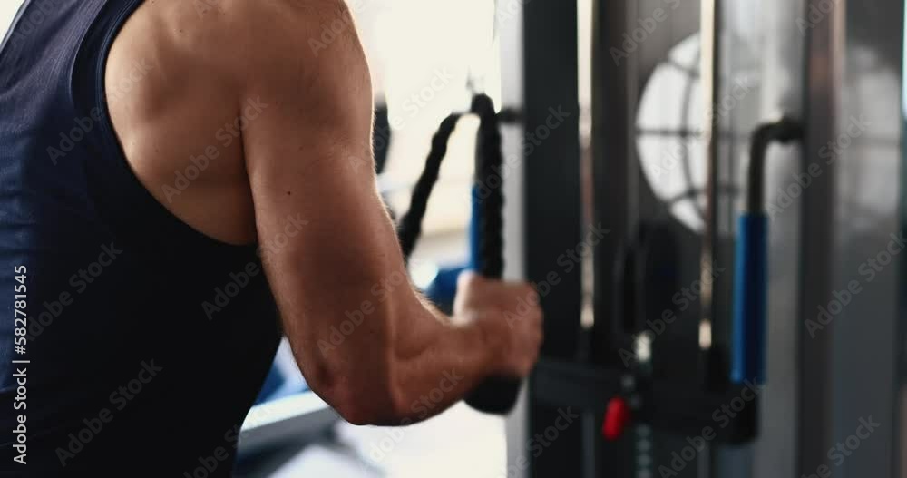 A man doing tricep on a block exercise in a gym A man doing tricep on a block exercise in a gym