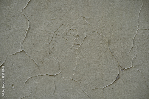 Peeling plaster on a cream concrete wall with copy space. Abstract textured background graphic element. photo