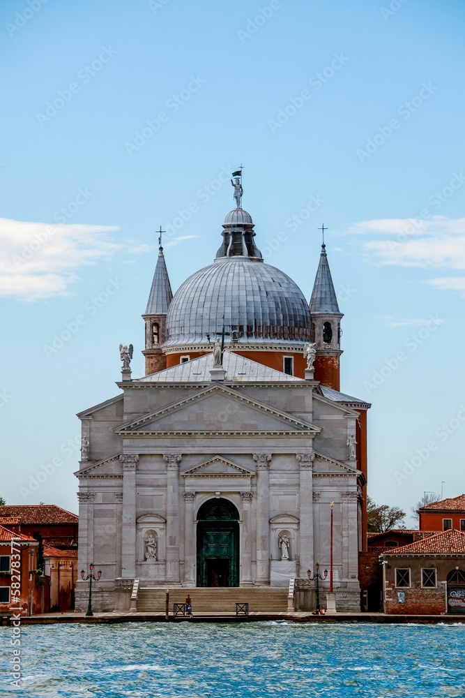 Vertical shot of the Il Redentore and Santissimo Cathedral across the water in Venice, Italy