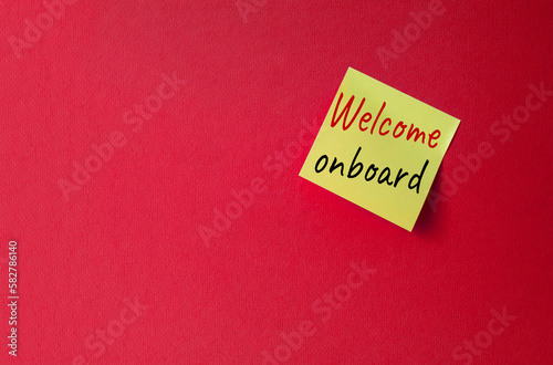 Welcome onboard symbol. Concept words Welcome onboard on orange steaky note. Beautiful red background. Business and Welcome onboard concept. Copy space.