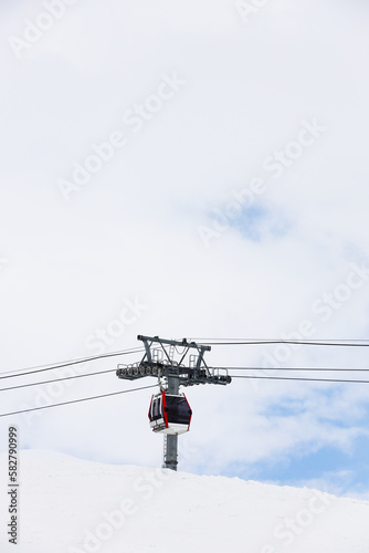 cable car are move on snowy mountain with skiers top view