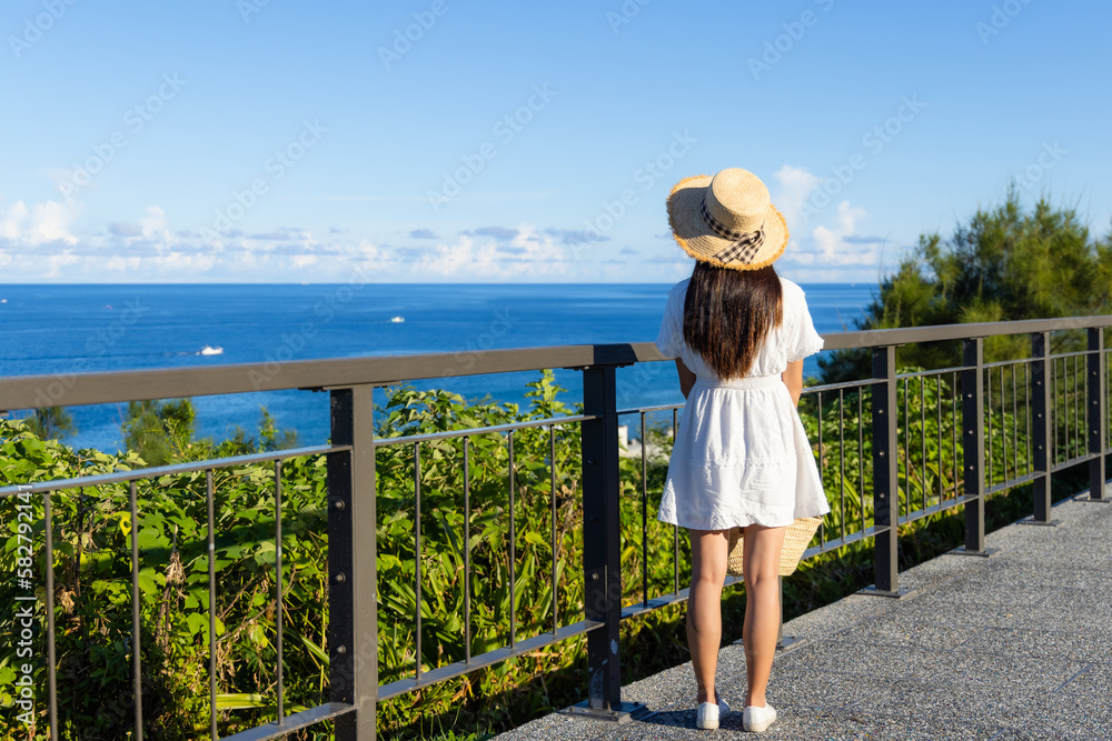 Woman with white dress and enjoy the sea view with blue sky