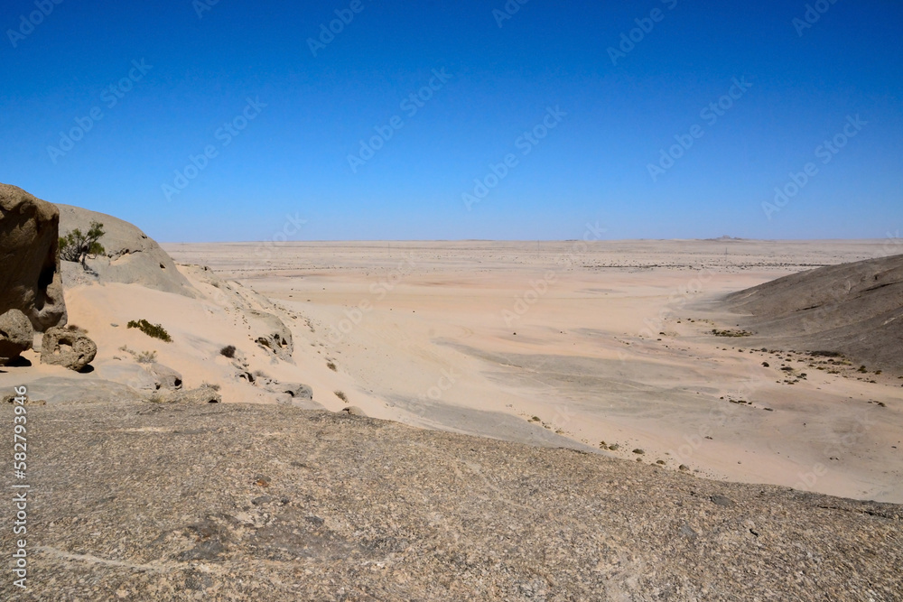 Waterless desert valley to the horizon against the background of the blue sky. Climate change and global warming