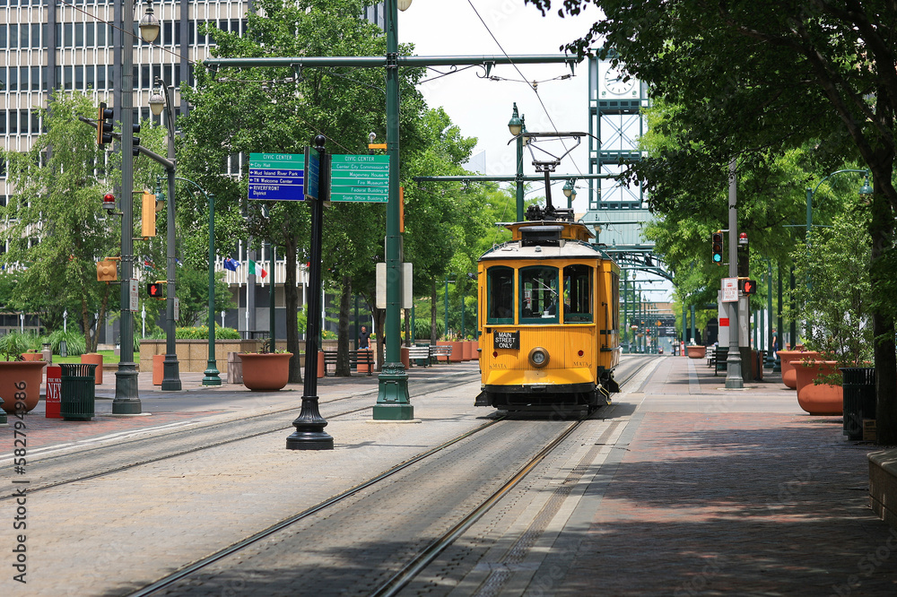 Fototapeta premium A yellow electric trolley on Main Street in downtown Memphis, Tennessee in summer