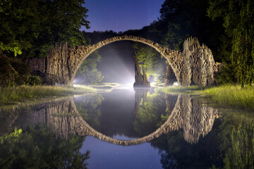 Papier peint photo Le Rakotzbrücke Rakotzbrücke nocturne sous ciel étoilé  © ddpix