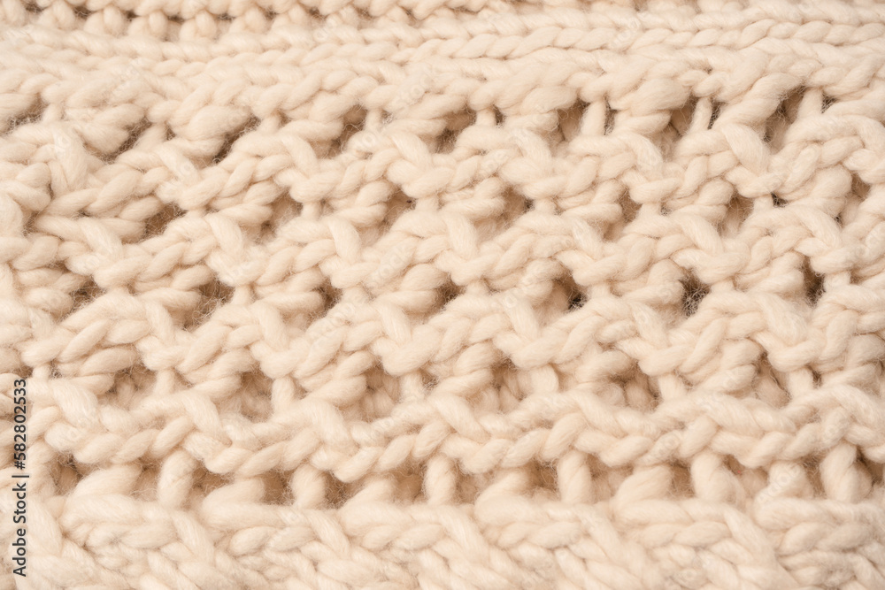 A fragment of beige knitted fabric, knitted from white sheep wool. A fragment of beige knitted fabric, knitted from white sheep wool.