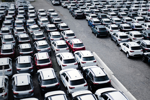 A parking lot with many new cars. An aerial view of an open-air parking lot.
