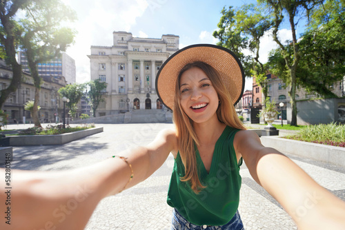 Tourism in Santos, Brazil. Happy cheerful traveler girl takes self portrait in Maua square in the historic center of Santos, Brazil. photo
