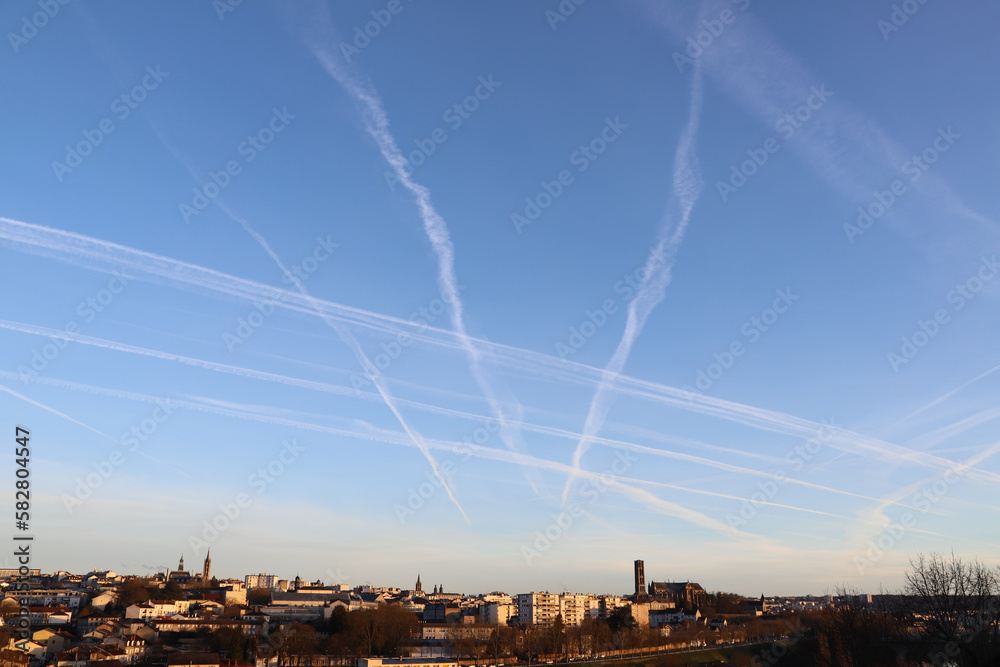 Ville sous un ciel à trainées de condensation