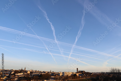 Obraz na płótnie Ville sous un ciel à trainées de condensation w salonie