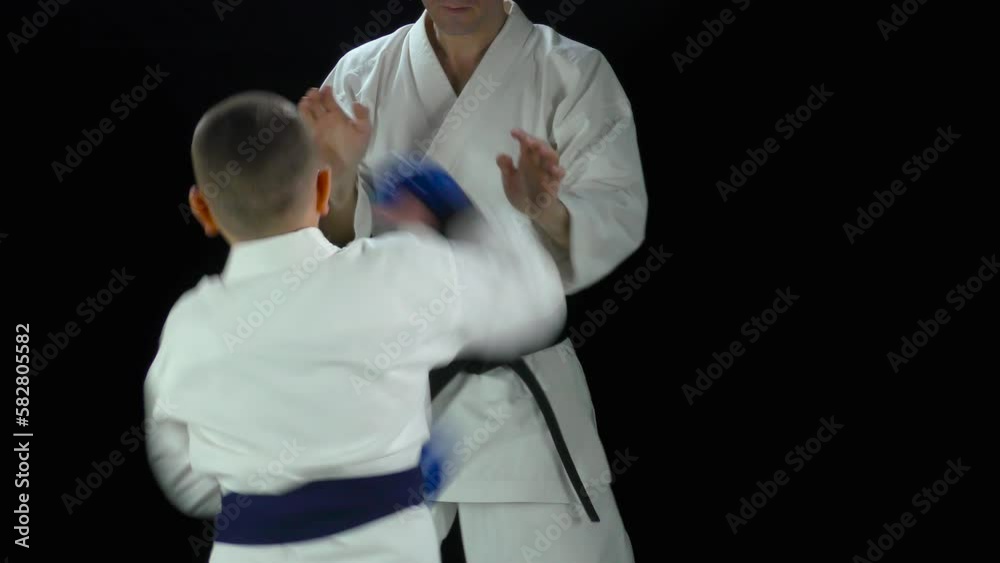 Athlete with blue pads on his hands beats punches on the hands of the coach Athlete with blue pads on his hands beats punches on the hands of the coach