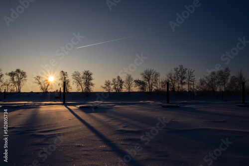 A image of a marina in the winter, snow covered and lonely with a setting sun after a long winter day. © Brian