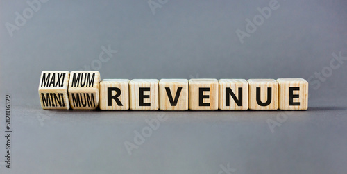 Maximum or minimum revenue symbol. Concept words Maximum revenue and Minimum revenue on wooden cubes. Beautiful grey table grey background. Business maximum or minimum revenue concept. Copy space.