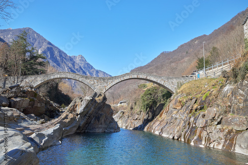 View of the medieval double arched bridge called Ponte dei Salti crossing the Verzasca river in the town of Lavertezzo, Switzerland.