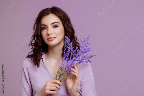 Photos Portrait of an attractive brunette in a dress with a bouquet in her hands