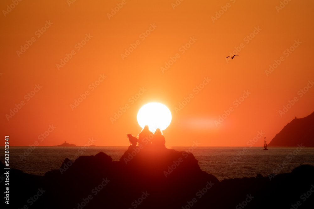 Pareja y perro en puesta de sol