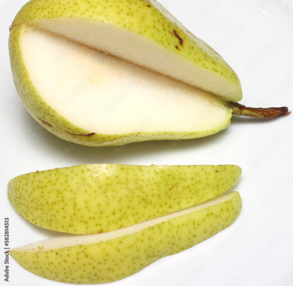 pear with some cuts. green fruit. pear and pieces in the white background. pear slices.