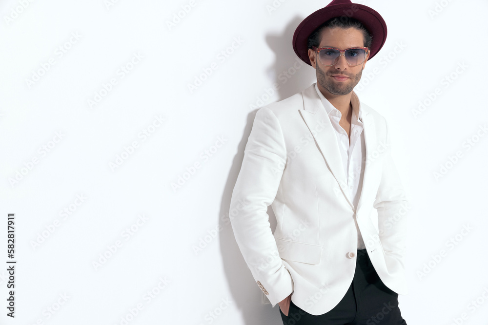 proud young man with hat and glasses holding hands in pockets proud young man with hat and glasses holding hands in pockets