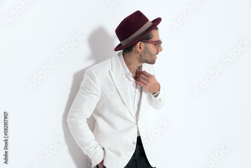 elegant young man with hat and sunglasses looking to side