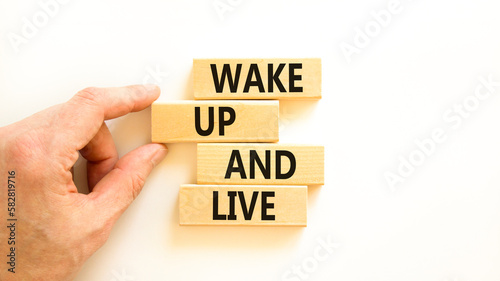 Wake up and live symbol. Concept words Wake up and live on wooden blocks. Beautiful white table white background. Businessman hand. Business lifestyle wake up and live concept. Copy space.