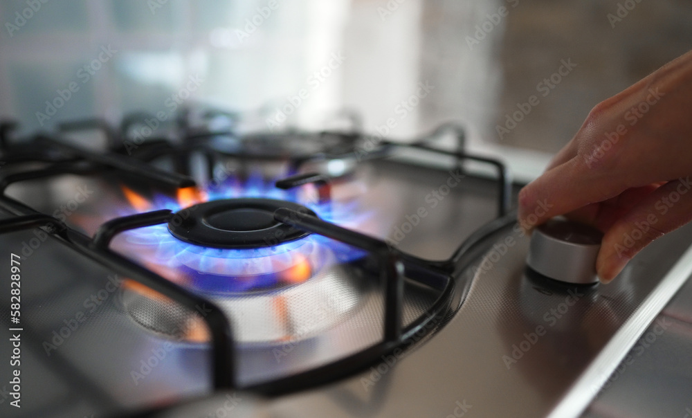 Εκτύπωση καμβά Woman turning on the gas burner on the stove.