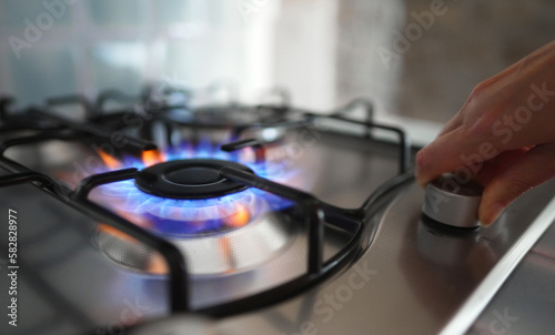 Woman turning on the gas burner on the stove.