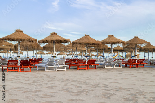 Palm umbrellas on the beach in the popular resort of Torremolinos on the Mediterranean Sea in Spain. photo