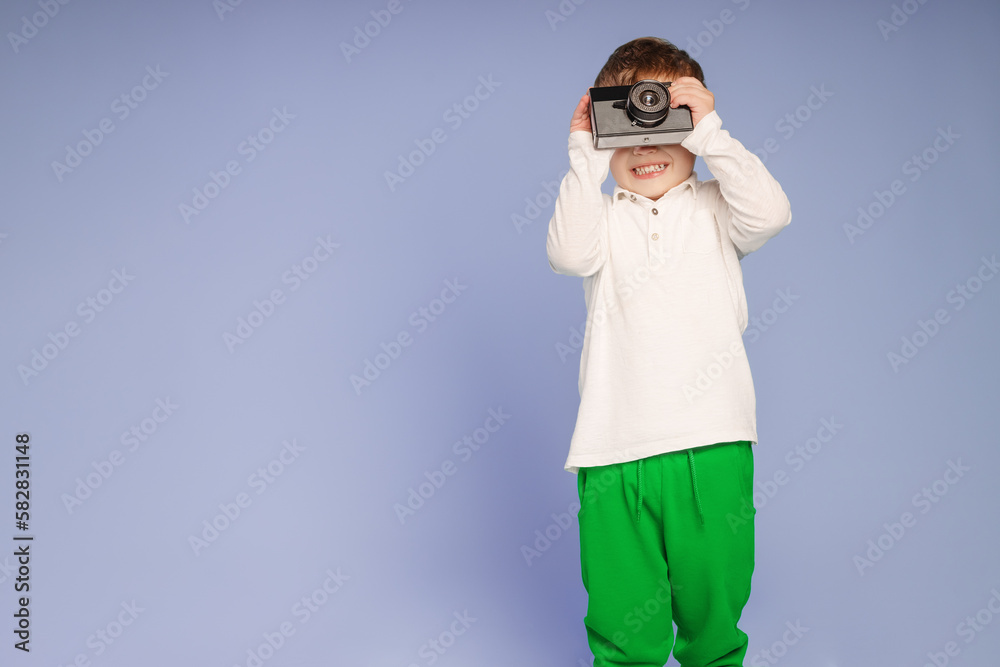 happy Little boy in white shirt do a photo with retro camera as a professional happy Little boy in white shirt do a photo with retro camera as a professional