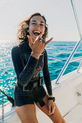 Excited and joyful young athletic woman, prepares for swimming on beach vacation, having fun in the tropical water, with a big toothy smile, laughing, enjoying her honeymoon	