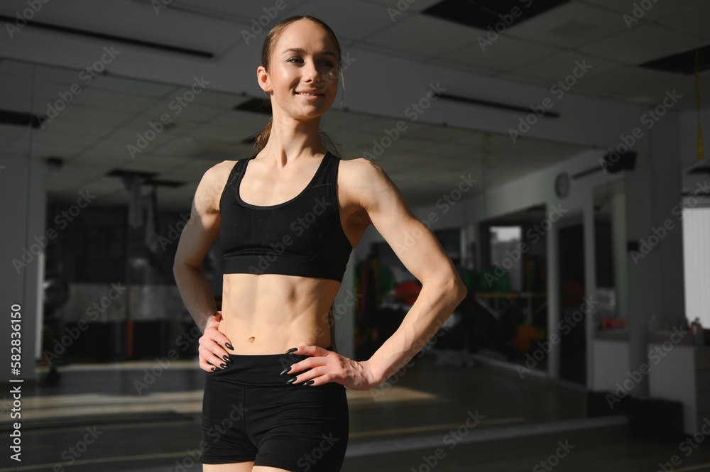 Image of a beautiful strong happy cheerful young sports woman posing at gym Image of a beautiful strong happy cheerful young sports woman posing at gym