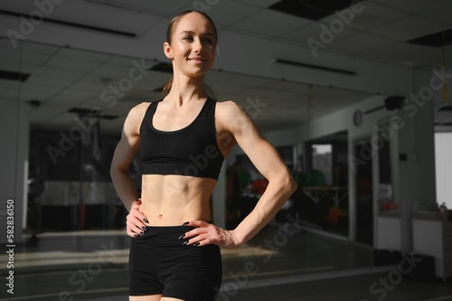 Image of a beautiful strong happy cheerful young sports woman posing at gym