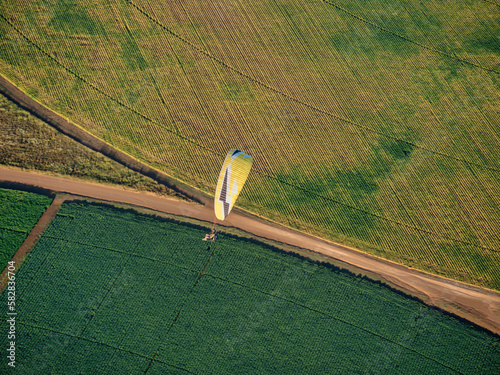 Powered paraglider flying over crops fields the Magaliesburg, Gauteng, South Africa photo