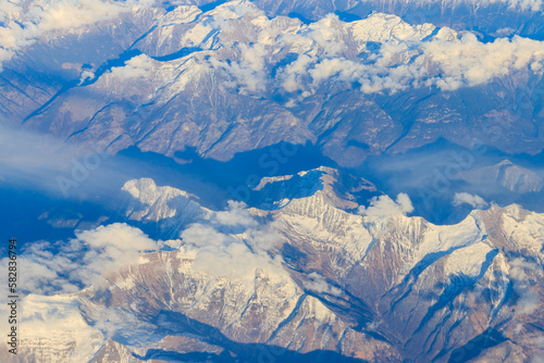 View of the Swiss Alps covered with snow from airplane © olyasolodenko