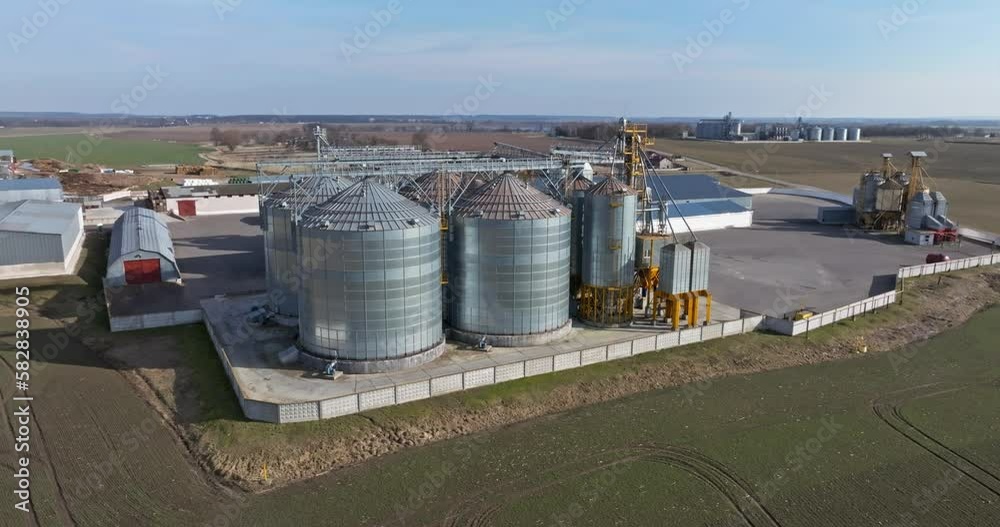 flight and aerial view over agro silos granary elevator on agro-processing manufacturing plant for processing drying cleaning and storage of agricultural products, flour, cereals and grain. flight and aerial view over agro silos granary elevator on agro-processing manufacturing plant for processing drying cleaning and storage of agricultural products, flour, cereals and grain.