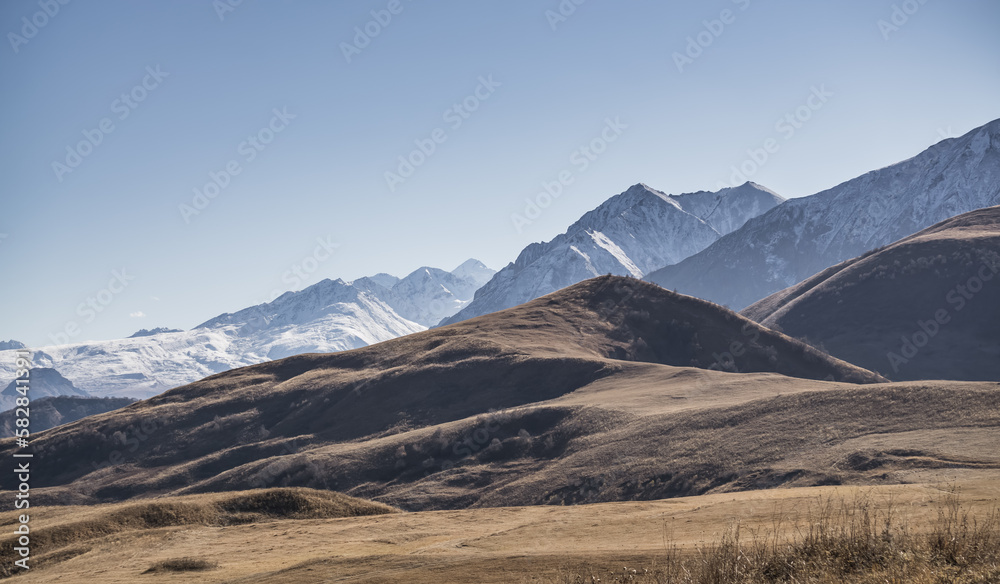 Panorama of a mountain range from layers of rocks with the first snow on the rocks and slopes, autumn mountains with the first snow Panorama of a mountain range from layers of rocks with the first snow on the rocks and slopes, autumn mountains with the first snow