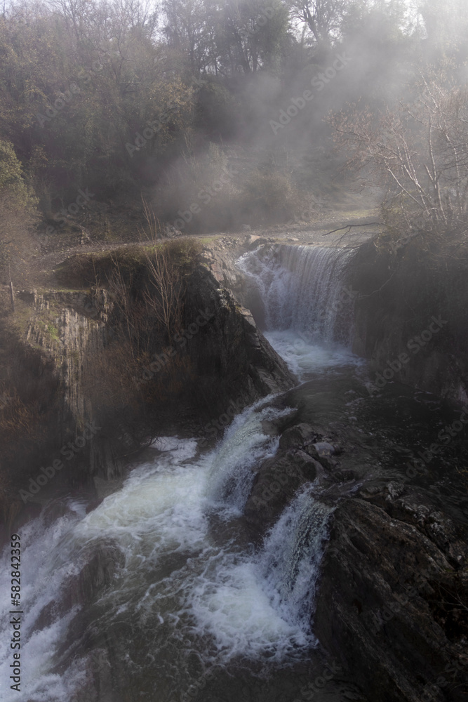 Obraz premium A mesmerizing display of nature: The magnificent Delika Waterfall amidst the misty mountains of Vizcaya