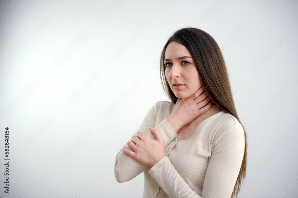 Young woman touching painful neck, sore throat for flu, cold and infection. High quality photo girl holding her throat young beautiful long hair white background Young woman touching painful neck, sore throat for flu, cold and infection. High quality photo girl holding her throat young beautiful long hair white background