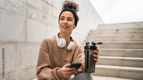 Fototapeta Naklejka Na Ścianę i Meble -  One young woman caucasian female hold supplement shaker outdoor in day