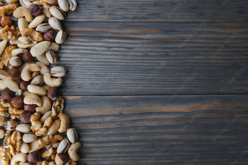 mixed nuts in a bowl on wooden table, top view with copy space. mixed nuts in a bowl on wooden table, top view with copy space.