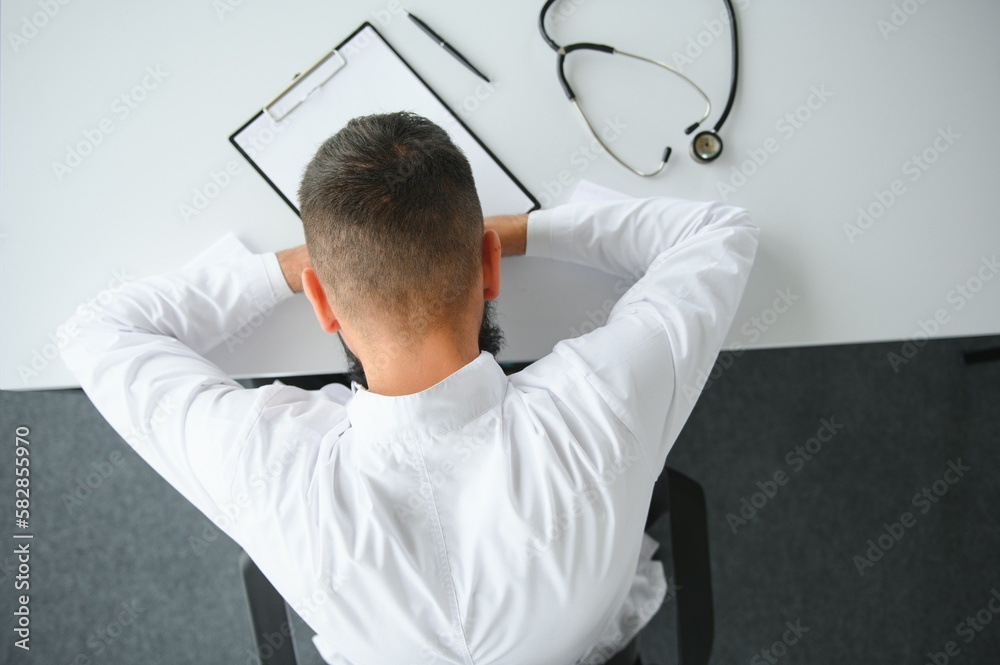 Fototapeta premium Portrait of exhausted tired young arab male doctor after hard day at work